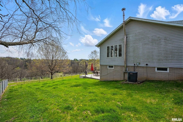 view of property exterior featuring central AC, fence, a patio, and a yard