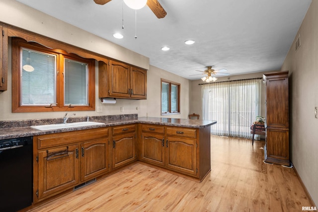 kitchen with a ceiling fan, dishwasher, a peninsula, and brown cabinetry