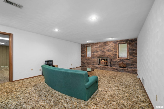 carpeted living area with recessed lighting, brick wall, a brick fireplace, visible vents, and baseboards