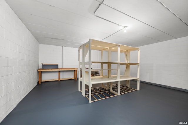 additional living space featuring concrete block wall and finished concrete floors