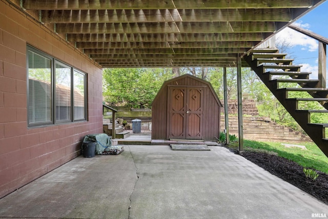 view of patio with an outdoor structure, a shed, and stairs
