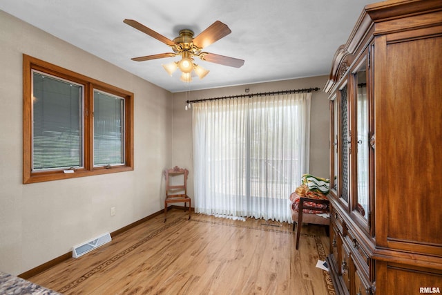 spare room with light wood finished floors, visible vents, ceiling fan, and baseboards