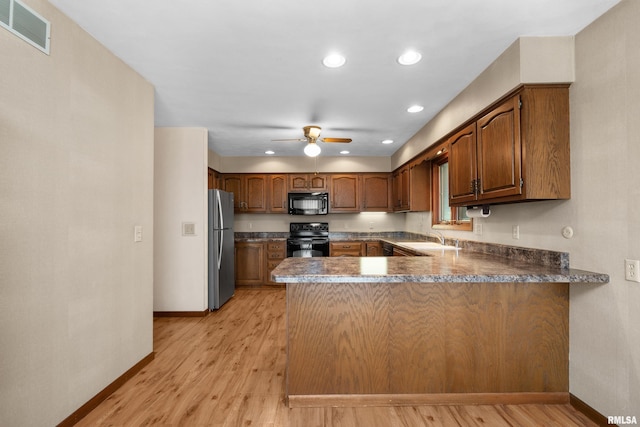 kitchen featuring a sink, ceiling fan, black appliances, visible vents, and a peninsula