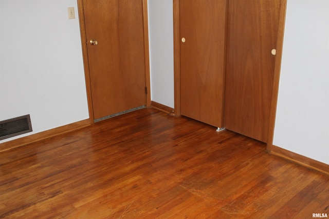2107 W 38th Pl, Davenport, IA 52806 - unfurnished bedroom with baseboards, visible vents, and wood finished floors