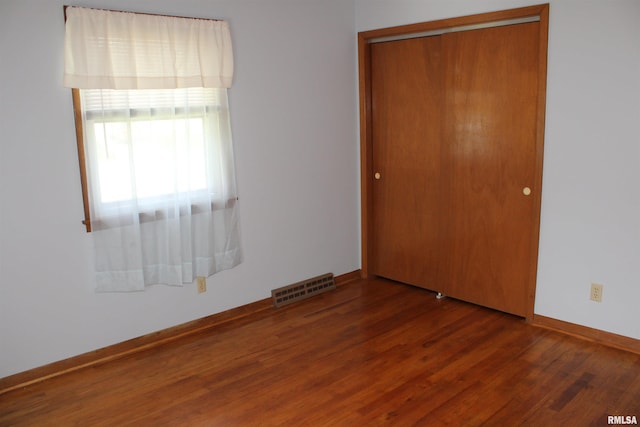 2107 W 38th Pl, Davenport, IA 52806 - unfurnished bedroom with visible vents, baseboards, wood finished floors, and a closet
