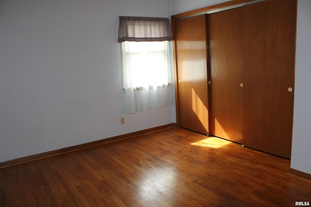 2107 W 38th Pl, Davenport, IA 52806 - unfurnished bedroom featuring baseboards, wood finished floors, and a closet