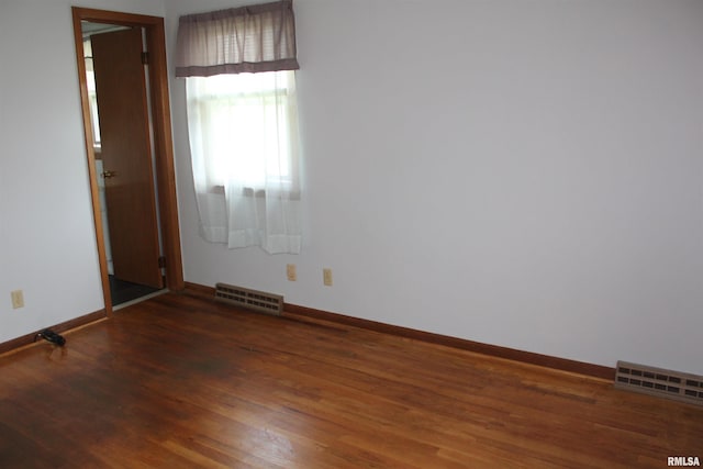 2107 W 38th Pl, Davenport, IA 52806 - unfurnished room with baseboards, visible vents, and wood finished floors
