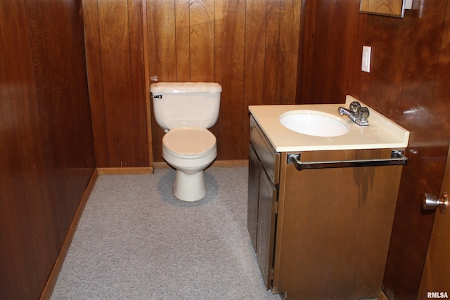 2107 W 38th Pl, Davenport, IA 52806 - bathroom with toilet, baseboards, wood walls, and vanity