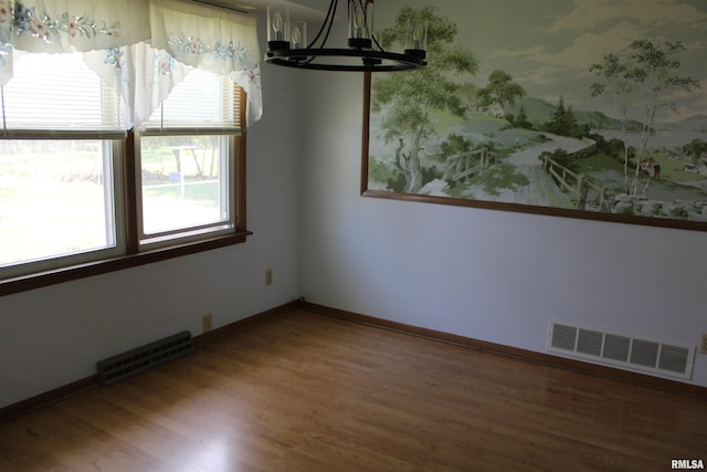 2107 W 38th Pl, Davenport, IA 52806 - unfurnished dining area with baseboards, a notable chandelier, visible vents, and wood finished floors