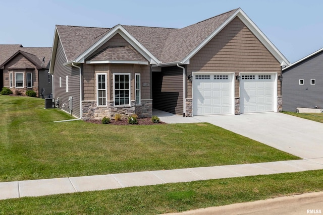 5120 Pandit Dr, Bettendorf, IA 52722 - view of front facade featuring concrete driveway, stone siding, a shingled roof, a front yard, and a garage