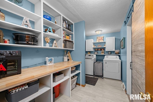 interior space featuring washing machine and clothes dryer, cabinet space, light wood-style floors, a textured ceiling, and a toaster