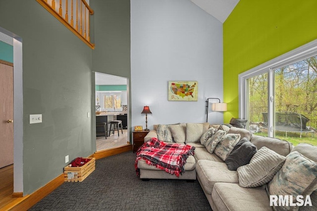living room with plenty of natural light, wood finished floors, and high vaulted ceiling