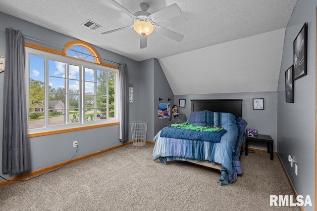carpeted bedroom featuring a textured ceiling, visible vents, baseboards, and lofted ceiling