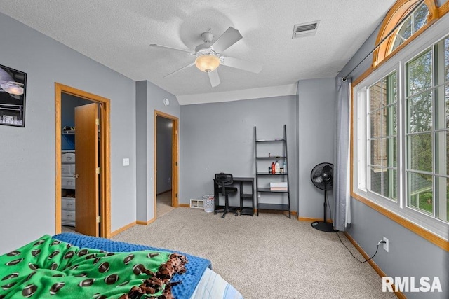 bedroom featuring carpet floors, multiple windows, a textured ceiling, and visible vents