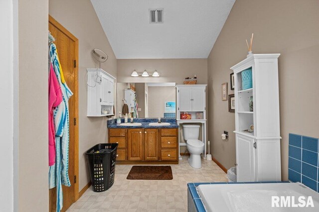 bathroom featuring visible vents, vanity, toilet, baseboards, and vaulted ceiling