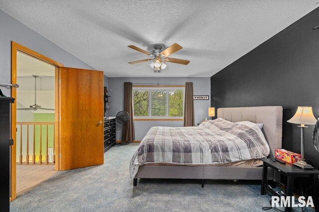 bedroom with a ceiling fan, a textured ceiling, and carpet