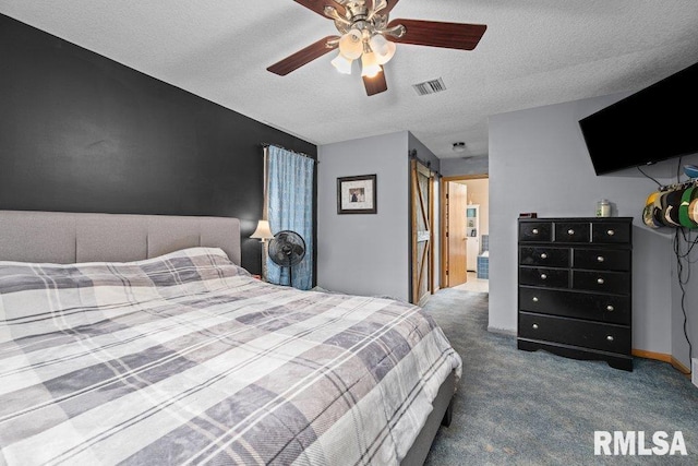 carpeted bedroom featuring a barn door, ceiling fan, a textured ceiling, and visible vents