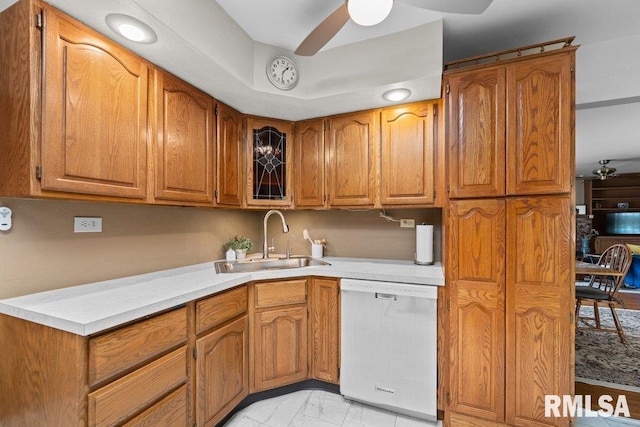kitchen featuring a sink, dishwasher, ceiling fan, and brown cabinetry