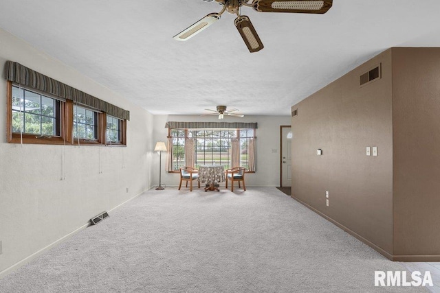 sitting room featuring visible vents, a ceiling fan, and baseboards
