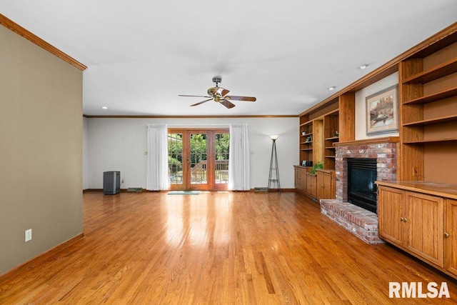 unfurnished living room featuring light wood finished floors, a fireplace, ceiling fan, baseboards, and ornamental molding