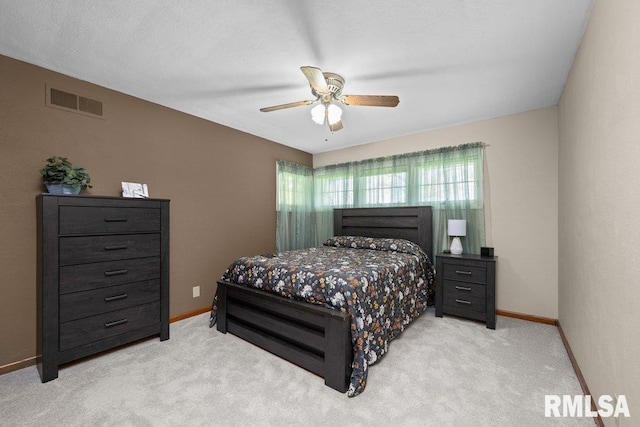 bedroom featuring baseboards, visible vents, a ceiling fan, and light colored carpet