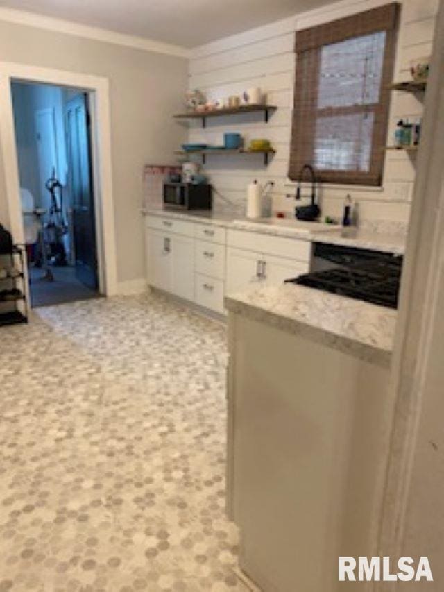 501 E Broad St, Jonesboro, IL 62952 - kitchen featuring crown molding, open shelves, white cabinetry, a sink, and cooktop