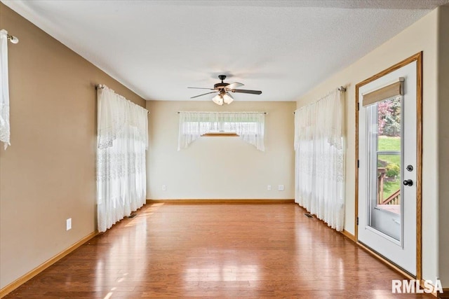 5200 Villa Dr, Davenport, IA 52806 - unfurnished room with plenty of natural light, a ceiling fan, baseboards, and wood finished floors