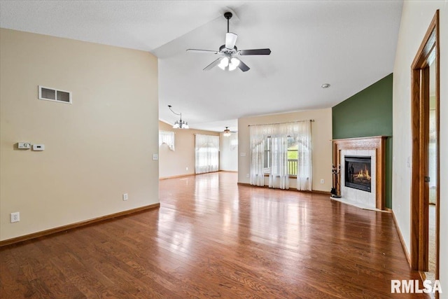 5200 Villa Dr, Davenport, IA 52806 - unfurnished living room featuring visible vents, a tiled fireplace, wood finished floors, high vaulted ceiling, and ceiling fan with notable chandelier
