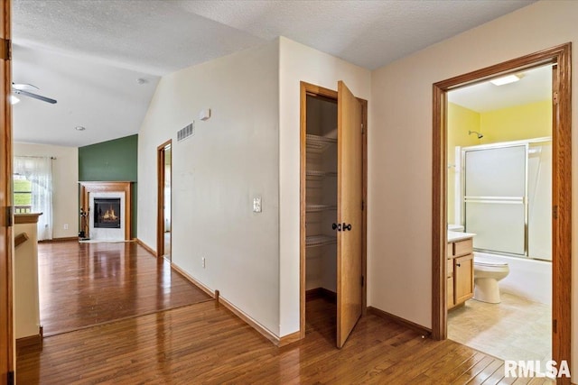 5200 Villa Dr, Davenport, IA 52806 - hall featuring visible vents, baseboards, wood finished floors, and vaulted ceiling