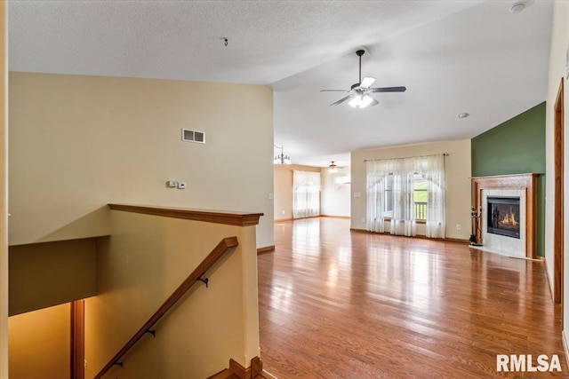 5200 Villa Dr, Davenport, IA 52806 - unfurnished living room featuring a ceiling fan, visible vents, wood finished floors, a tile fireplace, and high vaulted ceiling