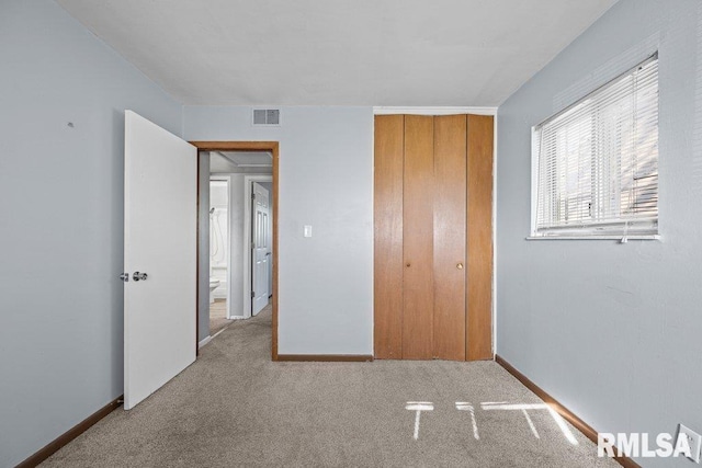 unfurnished bedroom featuring visible vents, baseboards, carpet floors, and a closet