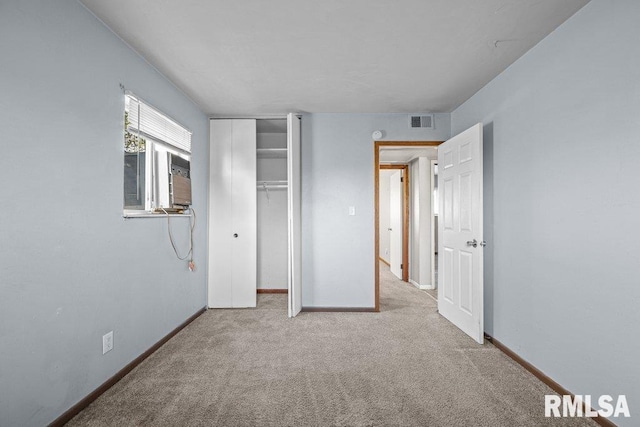 unfurnished bedroom featuring visible vents, baseboards, cooling unit, a closet, and carpet