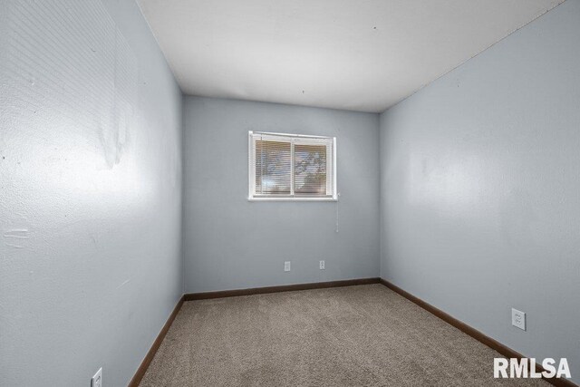 carpeted spare room with baseboards