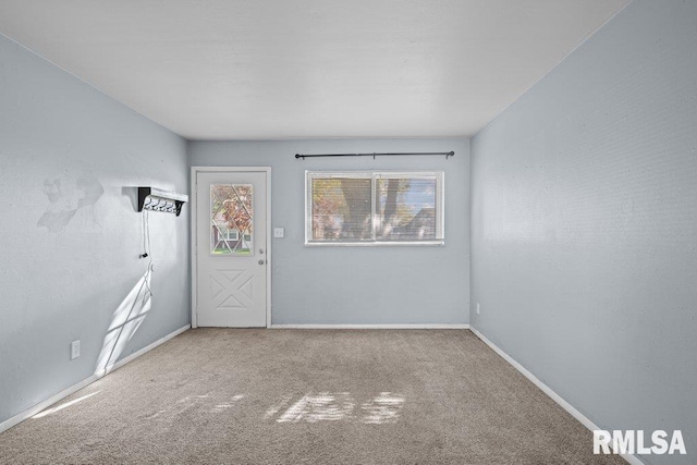 empty room featuring carpet floors and baseboards