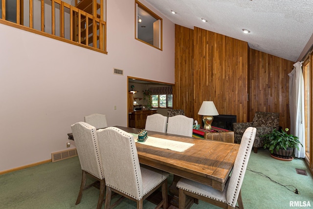 28018 230th St, Le Claire, IA 52753 - dining room featuring wooden walls, high vaulted ceiling, carpet flooring, and visible vents