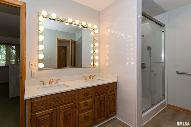 28018 230th St, Le Claire, IA 52753 - bathroom featuring a sink, a shower stall, double vanity, and wood finished floors