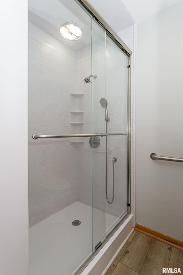 28018 230th St, Le Claire, IA 52753 - full bathroom featuring baseboards, a shower stall, and wood finished floors