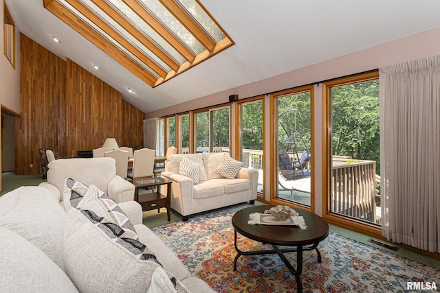 28018 230th St, Le Claire, IA 52753 - living area featuring visible vents, carpet floors, wooden walls, and high vaulted ceiling