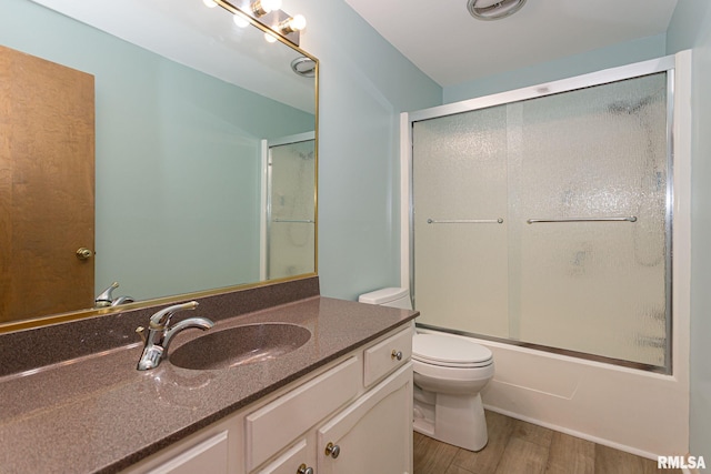 28018 230th St, Le Claire, IA 52753 - full bath featuring vanity, bath / shower combo with glass door, toilet, and wood finished floors