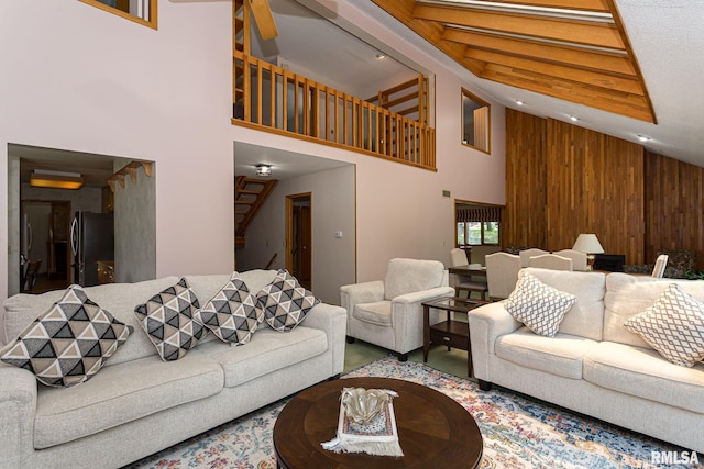 28018 230th St, Le Claire, IA 52753 - living area with stairs, high vaulted ceiling, and wood walls