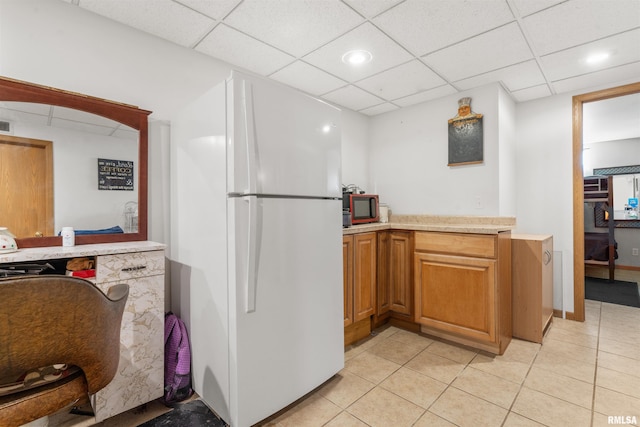 4012 172nd St N, East Moline, IL 61244 - kitchen with freestanding refrigerator, a drop ceiling, light tile patterned floors, and light countertops