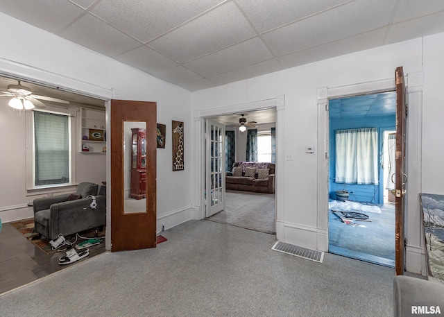 interior space with ceiling fan, visible vents, and a paneled ceiling