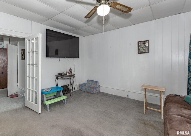 living room featuring carpet floors, a ceiling fan, and a paneled ceiling