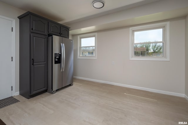 kitchen with baseboards, stainless steel fridge with ice dispenser, and light wood-type flooring