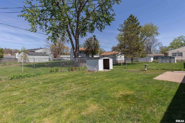 view of yard featuring an outdoor structure, a fenced backyard, and a storage shed