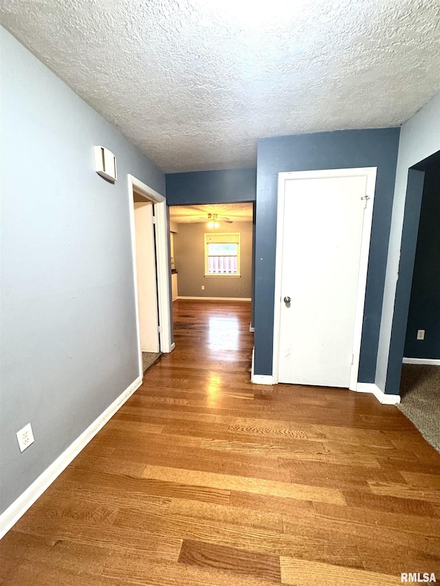 1001 W 6th St, West Frankfort, IL 62896 - hall with baseboards, a textured ceiling, and wood finished floors