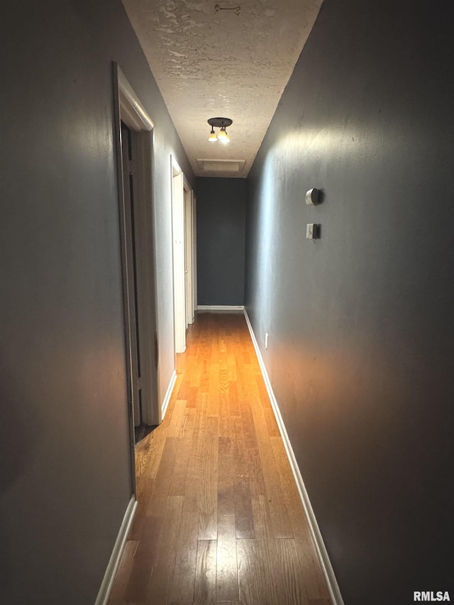 1001 W 6th St, West Frankfort, IL 62896 - hallway featuring baseboards, a textured ceiling, and light wood-style flooring