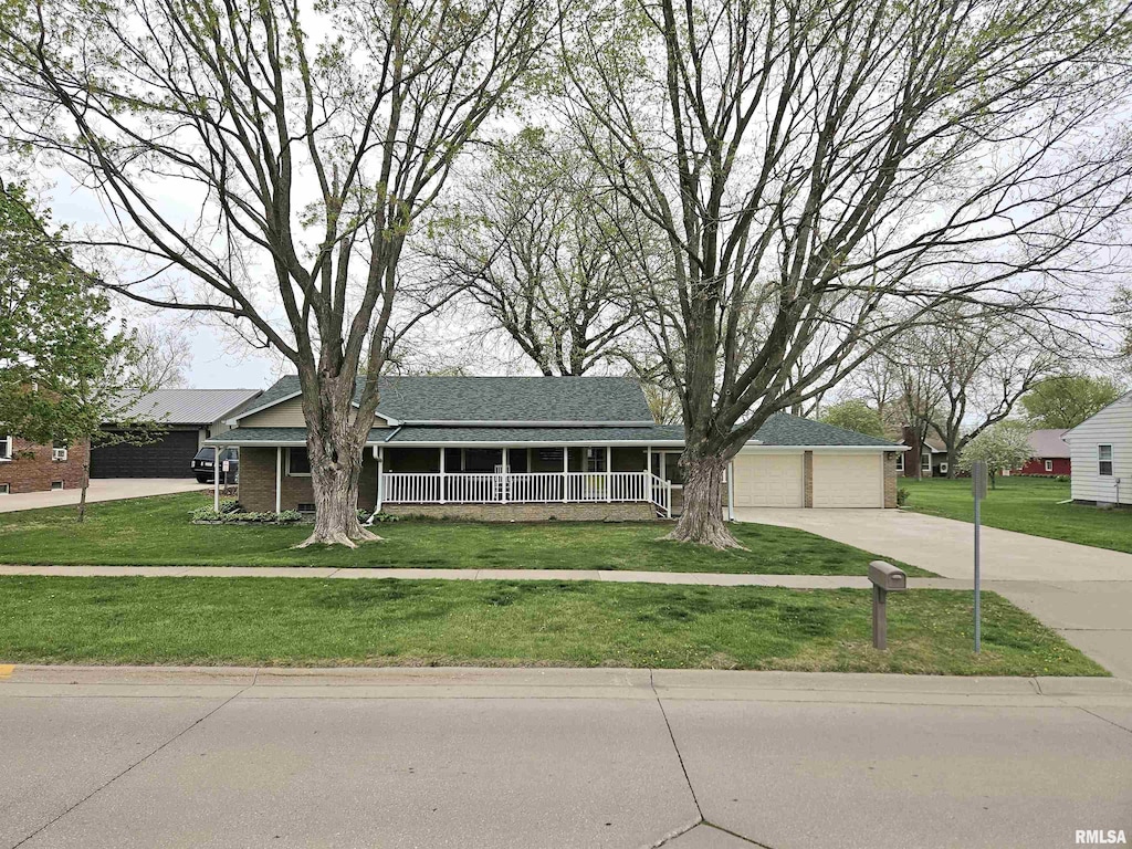 ranch-style house with concrete driveway and a front lawn