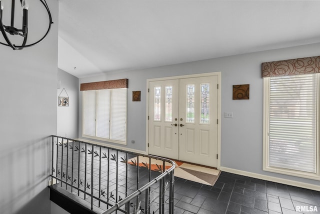 entrance foyer with baseboards and a chandelier
