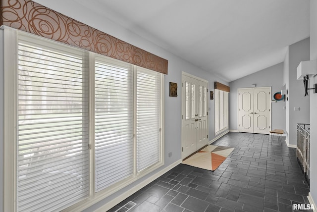 entrance foyer with baseboards and lofted ceiling